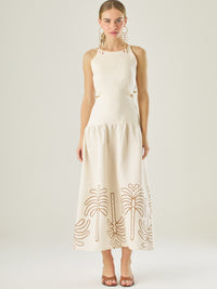 Vestido largo sin mangas con escote recto, aberturas laterales y detalle bordado en el bajo con motivos de inspiración natural. Su diseño limpio y femenino lo convierte en una opción ideal para un look sofisticado con un aire fresco y artesanal.
Detalles:
Color: Sand