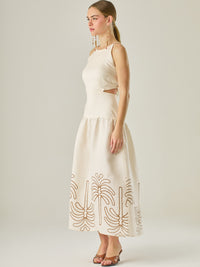 Vestido largo sin mangas con escote recto, aberturas laterales y detalle bordado en el bajo con motivos de inspiración natural. Su diseño limpio y femenino lo convierte en una opción ideal para un look sofisticado con un aire fresco y artesanal.
Detalles:
Color: Sand