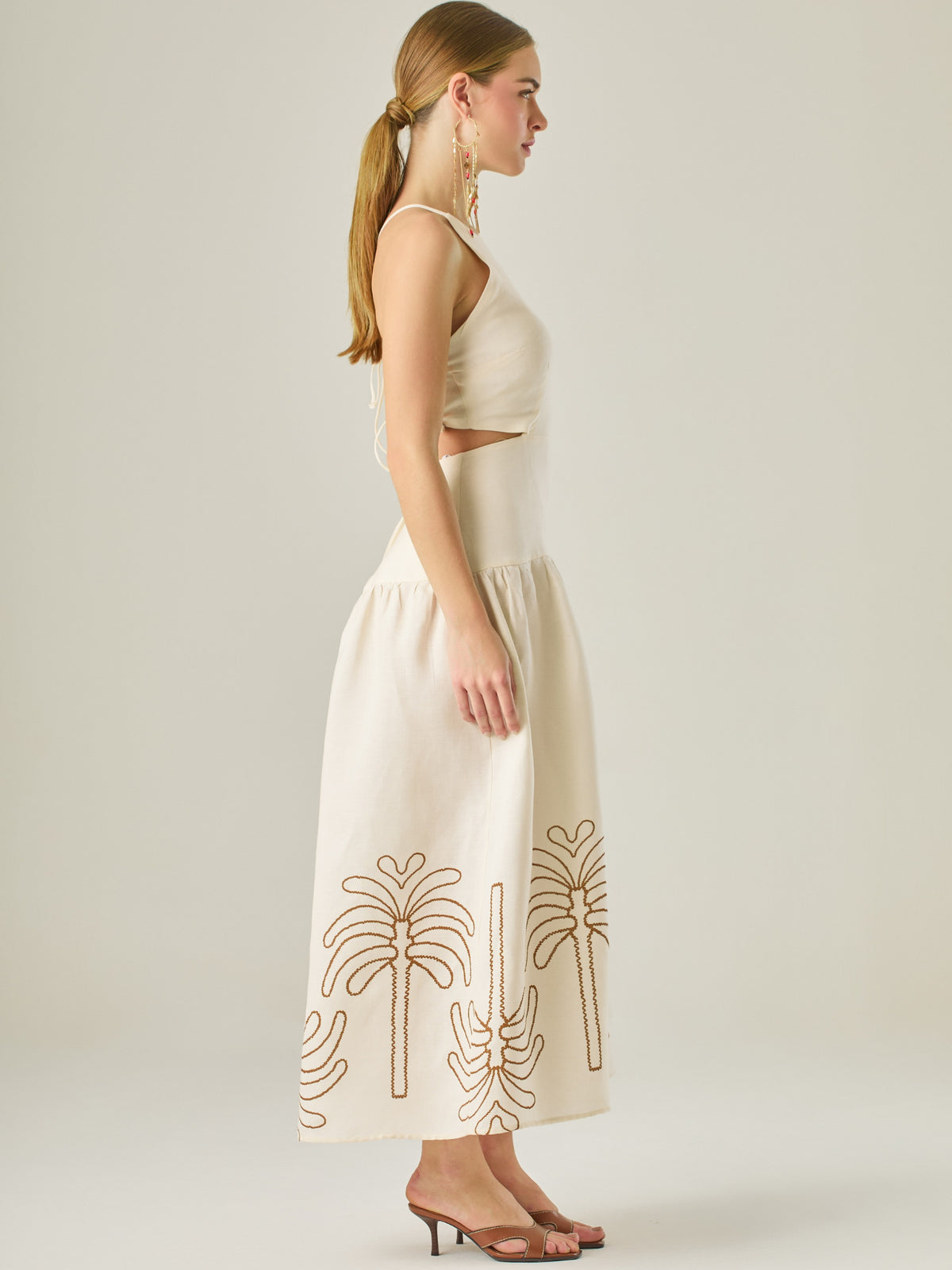 Vestido largo sin mangas con escote recto, aberturas laterales y detalle bordado en el bajo con motivos de inspiración natural. Su diseño limpio y femenino lo convierte en una opción ideal para un look sofisticado con un aire fresco y artesanal.
Detalles:
Color: Sand