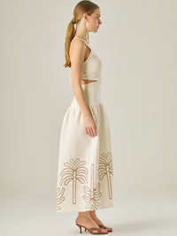 Vestido largo sin mangas con escote recto, aberturas laterales y detalle bordado en el bajo con motivos de inspiración natural. Su diseño limpio y femenino lo convierte en una opción ideal para un look sofisticado con un aire fresco y artesanal.
Detalles:
Color: Sand