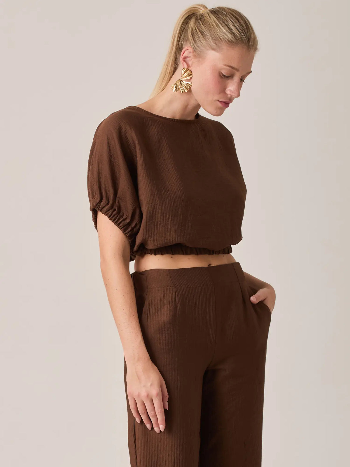 Diseñada para un estilo relajado pero refinado, la Blusa Agostina Café combina comodidad y tendencia. Su diseño corto con mangas amplias la convierte en una opción versátil para cualquier temporada.