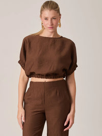 La Blusa Agostina Café presenta un diseño minimalista con ajuste en cintura que estiliza el cuerpo. Es una prenda ideal para looks monocromáticos o conjuntos coordinados de moda femenina.