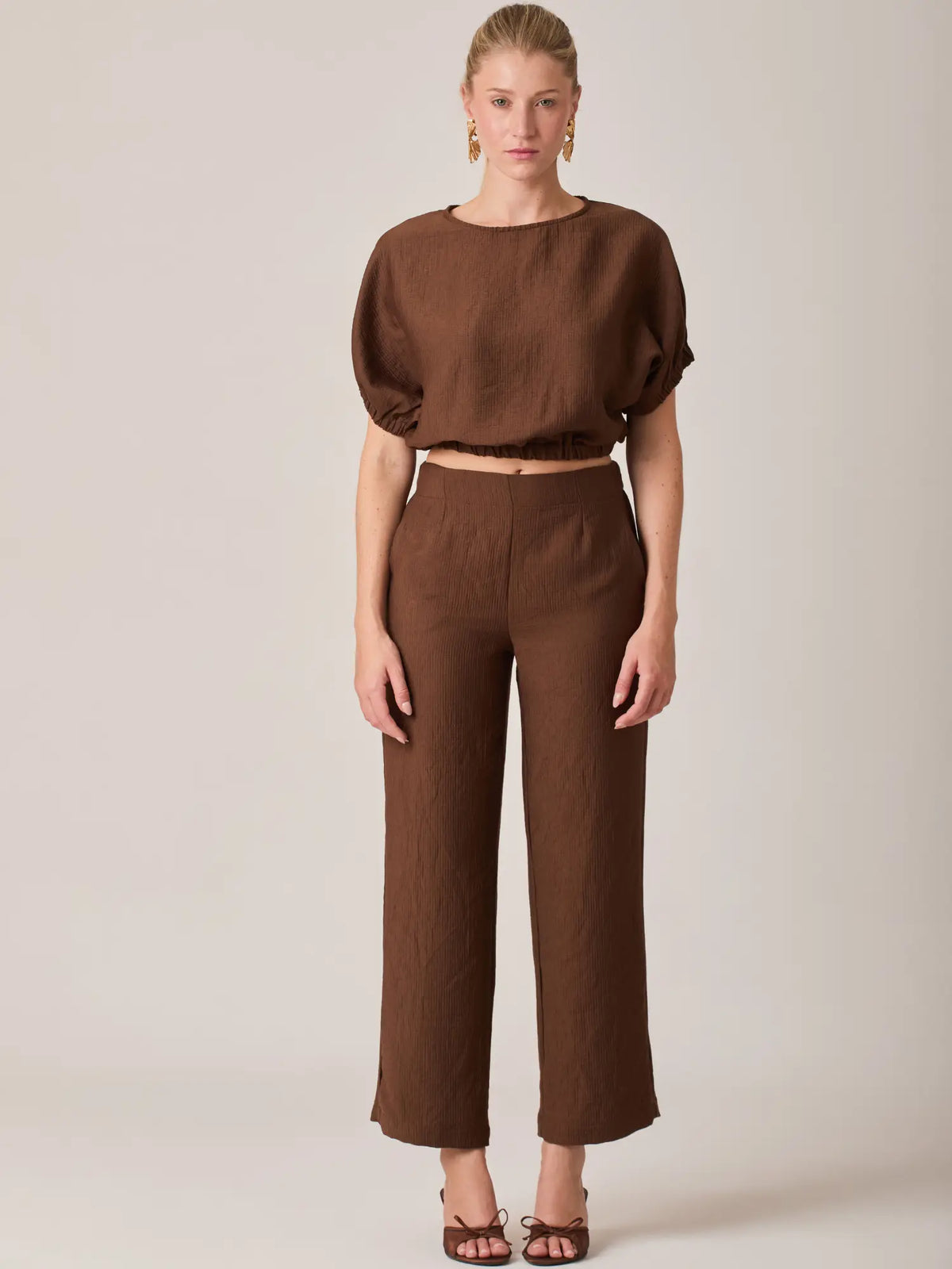 La Blusa Agostina Café es una pieza clave del guardarropa femenino gracias a su diseño funcional y elegante. Ideal para combinar con pantalones amplios, faldas o jeans de tiro alto.