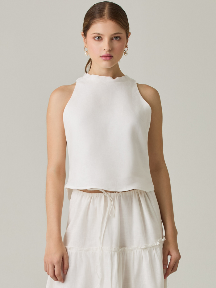 Esta blusa sin mangas refleja una elegancia natural con su cuello redondeado y acabado suave. El diseño se enfoca en la simplicidad, resaltando su frescura y ligereza. Perfecta para combinar con faldas o pantalones, ofrece una versatilidad ideal para días cálidos o eventos casuales.

Detalles:

Color: Blanco Perla

Material: 100% lino. 