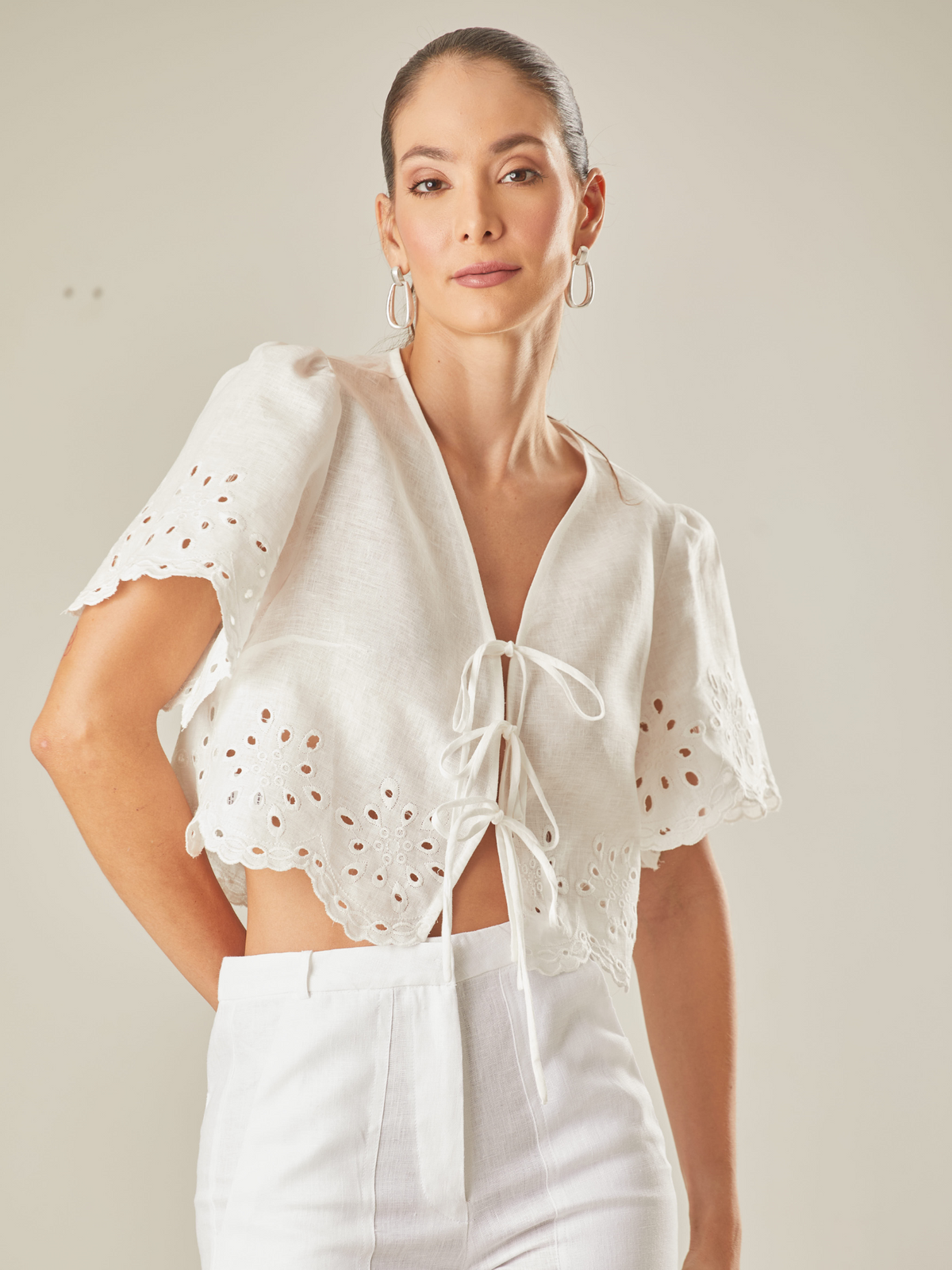 Blusa con guipiur, silueta corta y cierre con finos tirantes delantero, manga corta, estote pico, perfecta para días de playa o eventos especiales por su confección en lino 

Color: Blanco Perla 