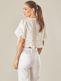 Blusa con guipiur, silueta corta y cierre con finos tirantes delantero, manga corta, estote pico, perfecta para días de playa o eventos especiales por su confección en lino 

Color: Blanco Perla 

Composición: 100% Lino 