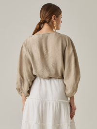 Blusa tipo campana, detalle de tono, manga de silueta larga con elástico.

Color: Taupe.

Composición: 85% Rayón 15% Naylon 