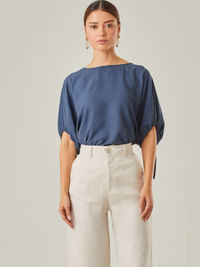 Blusa con un estilo relajado que combina comodidad y elegancia. Las mangas voluminosas, ajustables con delicados lazos, le otorgan un toque versátil, mientras que su corte fluido favorece una caída natural. Perfecta para crear looks modernos y atemporales.