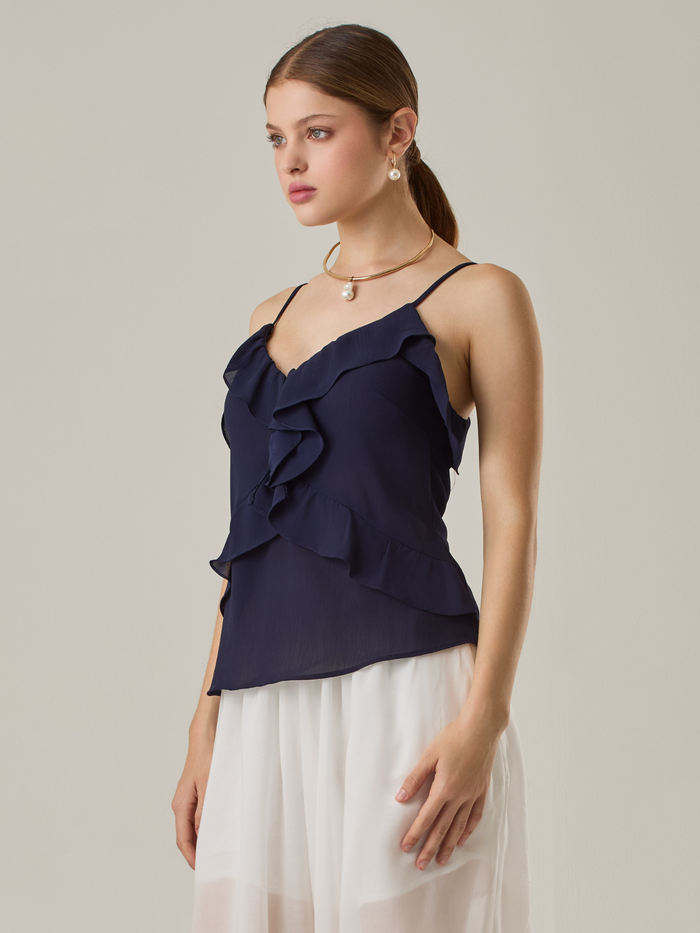 Blusa sin mangas y finos tirantes. Con un diseño minimalista y sofisticado. Su corte en V y acabado ligero a tono la hacen perfecta para looks frescos y elegantes. 
