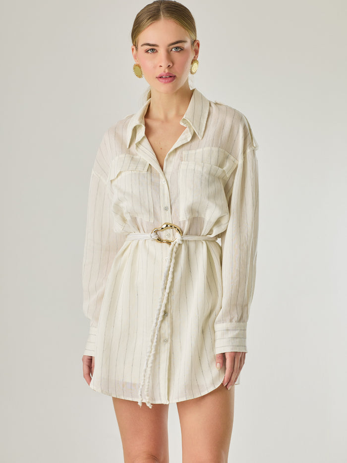 Blusa tipo camisera de manga larga con sutiles rayas y cinturón trenzado que define la figura. Su diseño ligero y relajado ofrece un estilo casual con toques elegantes, ideal para llevar con faldas o pantalones en looks versátiles y modernos.

Detalles:

Color: Blanco

Material: 77% Rayon 23% Nylon

Características: Incluye cinturón a tono.