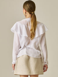 Blusa de manga larga con detalle de volantes en el escote y lazo largo para anudar. Su diseño ligero y delicado aporta movimiento y sofisticación, ideal para un look femenino con un aire romántico y moderno.

Detalles:
