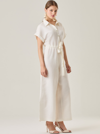 Enterizo con silueta amplia y cinturón ajustable que define la cintura. Su diseño de botones y mangas dobladas le da un toque sofisticado y versátil. Ideal para un look elegante y cómodo.

Detalles:

Color: Blanco Perla

Material: 50% Lino 50% Rayón

Características: Incluye cinturón a tono.