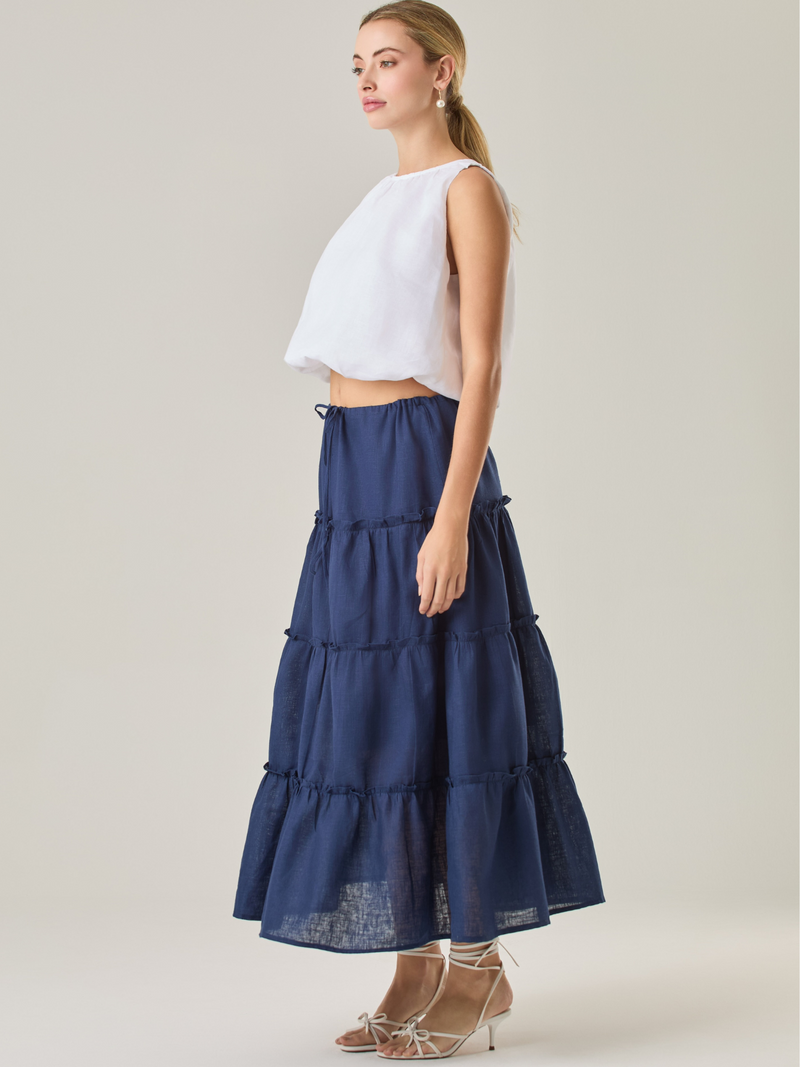 Esta falda larga de capas fruncidas aporta un aire fresco y fluido, ideal para un estilo relajado. Su pretina ajustable con cordón brinda comodidad y versatilidad, mientras que su caída ligera realza el movimiento natural de la prenda. Perfecta para combinar con blusas ligeras y looks casuales con un toque bohemio.