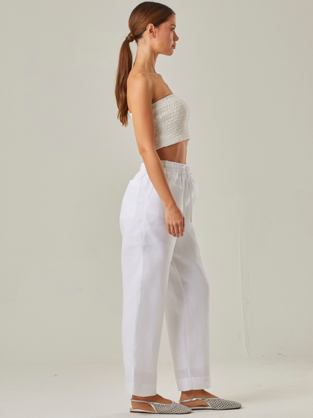 Pantalón con estilo relajado y cómodo, con un tiro alto que estiliza la silueta y una pretina elástica con cordón ajustable que garantiza un ajuste adaptable. Su tejido ligero aporta frescura, convirtiéndolo en la elección perfecta para climas cálidos o para quienes buscan una prenda versátil y funcional. A diferencia del primero, este diseño prescinde de bolsillos visibles, resaltando un acabado limpio y minimalista que se adapta fácilmente a distintos estilos,