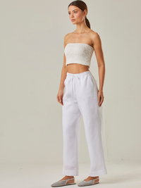 Pantalón con estilo relajado y cómodo, con un tiro alto que estiliza la silueta y una pretina elástica con cordón ajustable que garantiza un ajuste adaptable. Su tejido ligero aporta frescura, convirtiéndolo en la elección perfecta para climas cálidos o para quienes buscan una prenda versátil y funcional. A diferencia del primero, este diseño prescinde de bolsillos visibles, resaltando un acabado limpio y minimalista que se adapta fácilmente a distintos estilos, desde un look casual hasta uno más refinado s