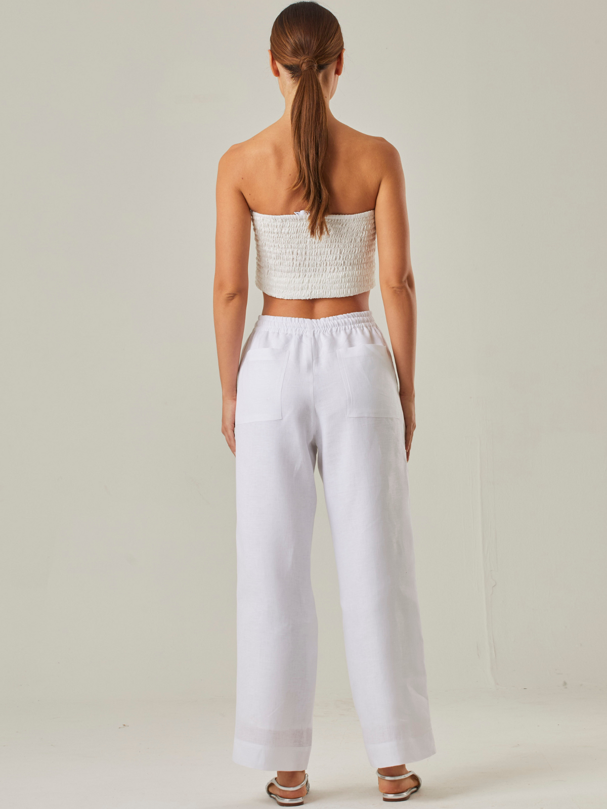 Pantalón con estilo relajado y cómodo, con un tiro alto que estiliza la silueta y una pretina elástica con cordón ajustable que garantiza un ajuste adaptable. Su tejido ligero aporta frescura, convirtiéndolo en la elección perfecta para climas cálidos o para quienes buscan una prenda versátil y funcional. A diferencia del primero, este diseño prescinde de bolsillos visibles, resaltando un acabado limpio y minimalista que se adapta fácilmente a distintos estilos, desde un look casual hasta uno más refinado s