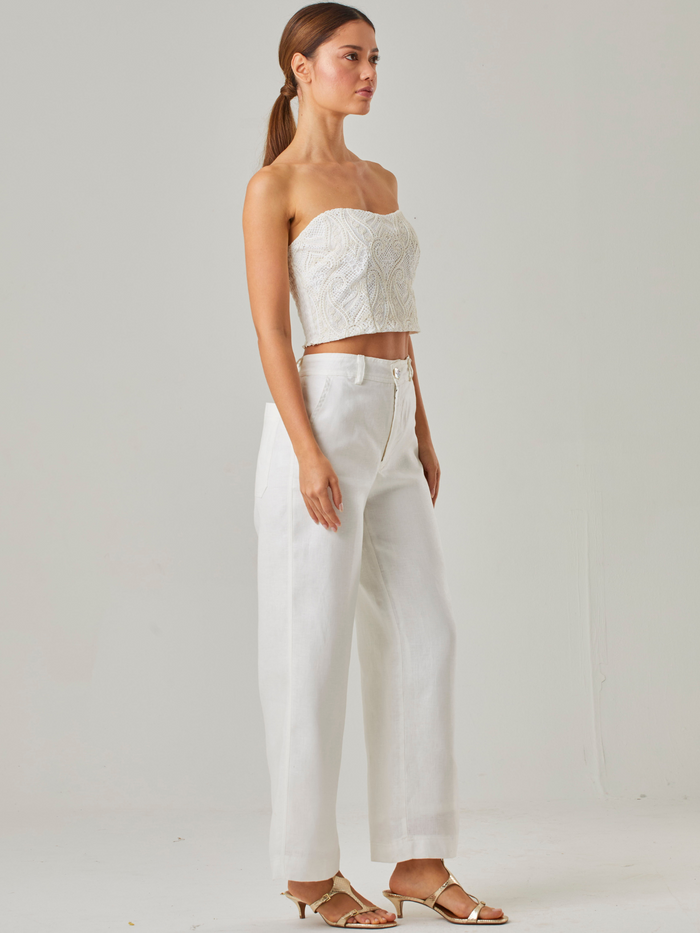 pantalón de tiro alto con un corte amplio que aporta fluidez y movimiento a cada paso. Su diseño incluye una pretina estructurada con botón en el centro, asegurando un ajuste favorecedor y elegante. Los bolsillos laterales añaden funcionalidad sin comprometer el estilo