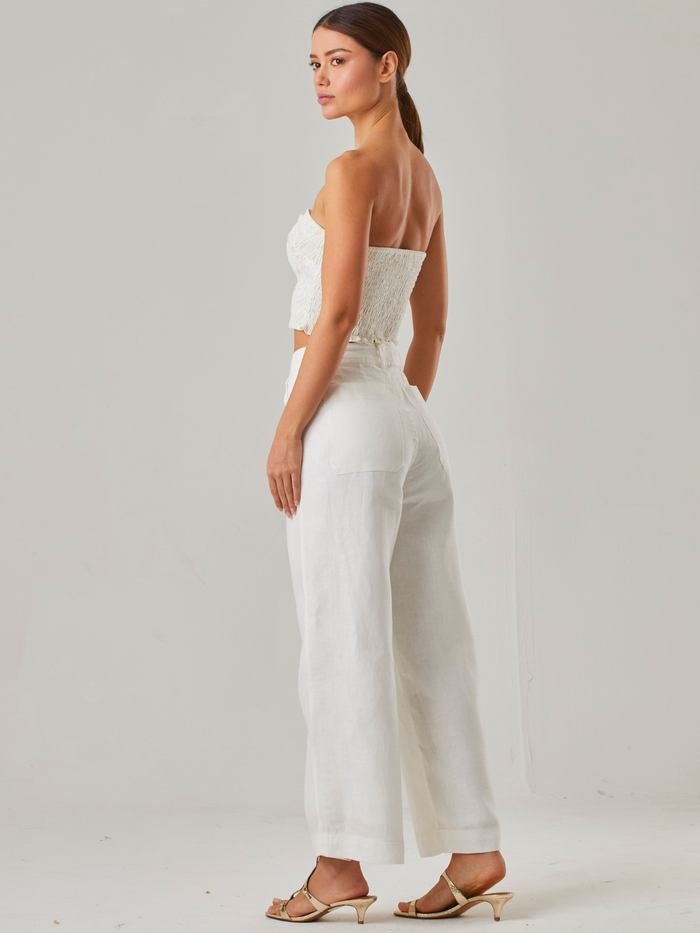 Los bolsillos laterales añaden funcionalidad sin comprometer el estilo, convirtiéndolo en una opción versátil para diferentes ocasiones. Su caída ligera y sofisticada lo hace ideal para combinar con blusas ajustadas o tops cortos, logrando un look equilibrado entre frescura y sofisticación.