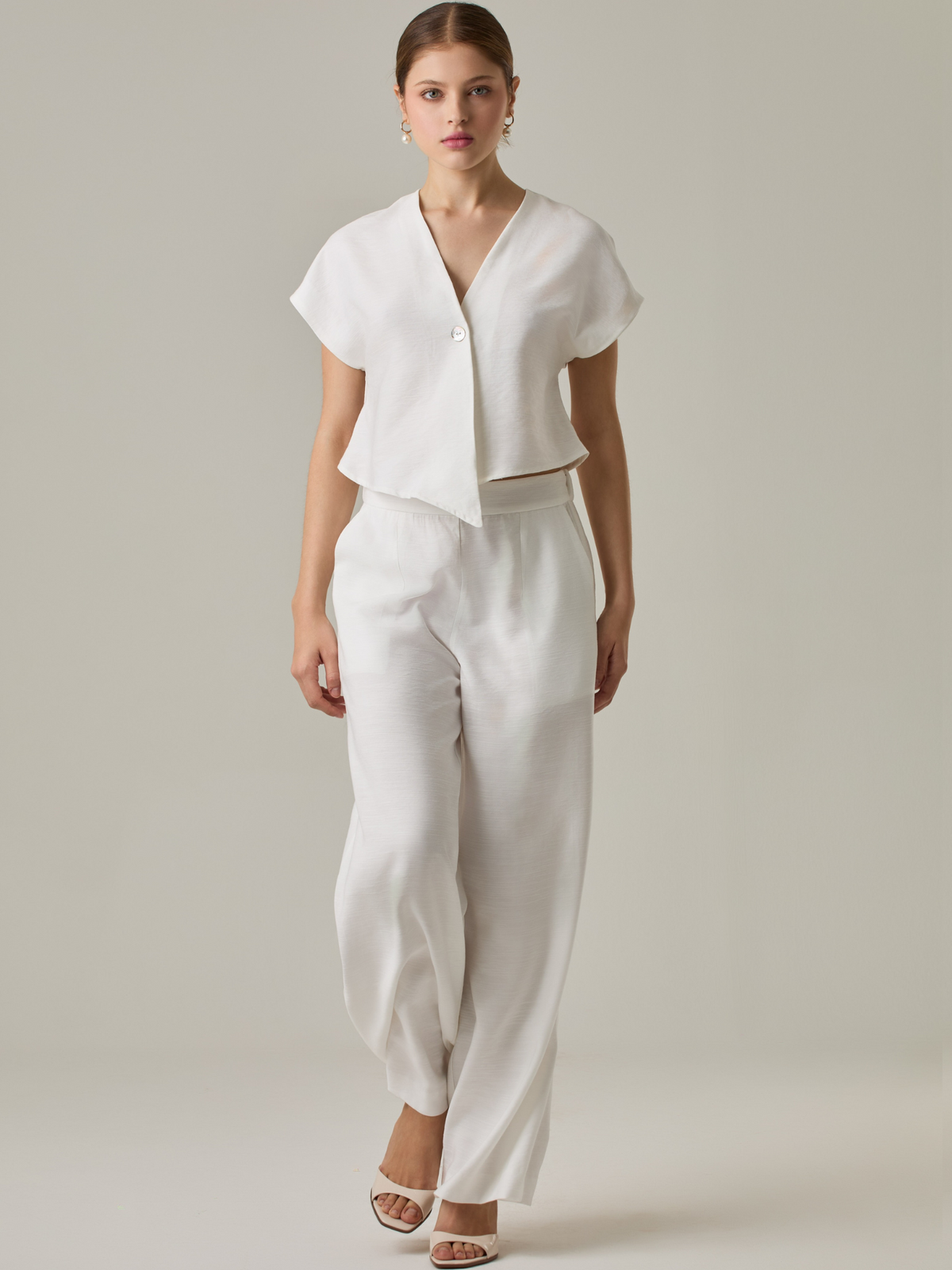 Pantalón de tiro alto y bota amplia que alarga visualmente la figura. Tiene una caída suelta y elegante que aporta movimiento con cada paso. Su diseño minimalista permite múltiples combinaciones, desde looks casuales hasta más sofisticados.

Detalles:

Color: Blanco Perla
