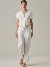 Pantalón de tiro alto y bota amplia que alarga visualmente la figura. Tiene una caída suelta y elegante que aporta movimiento con cada paso. Su diseño minimalista permite múltiples combinaciones, desde looks casuales hasta más sofisticados.

Detalles:

Color: Blanco Perla