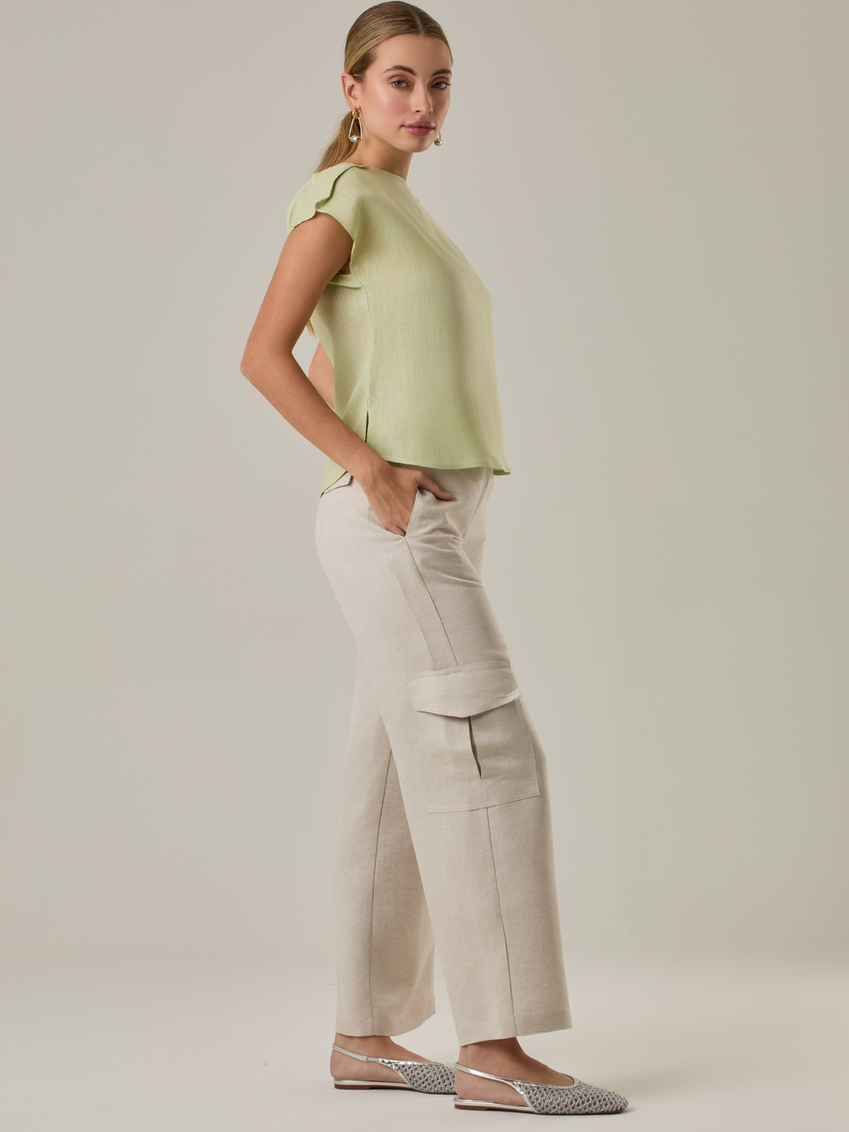 Pantalón amplio de tiro alto con bolsillos tipo cargo a los costados. Incluye cinturón del mismo tono con hebilla decorativa. Su silueta estructurada y el tono neutro lo convierten en una prenda versátil para looks casuales o sofisticados.

Color: Ivory

Material: 52% Lino 48% Rayón 

Características: Incluye  bolsillos laterales ocultos.