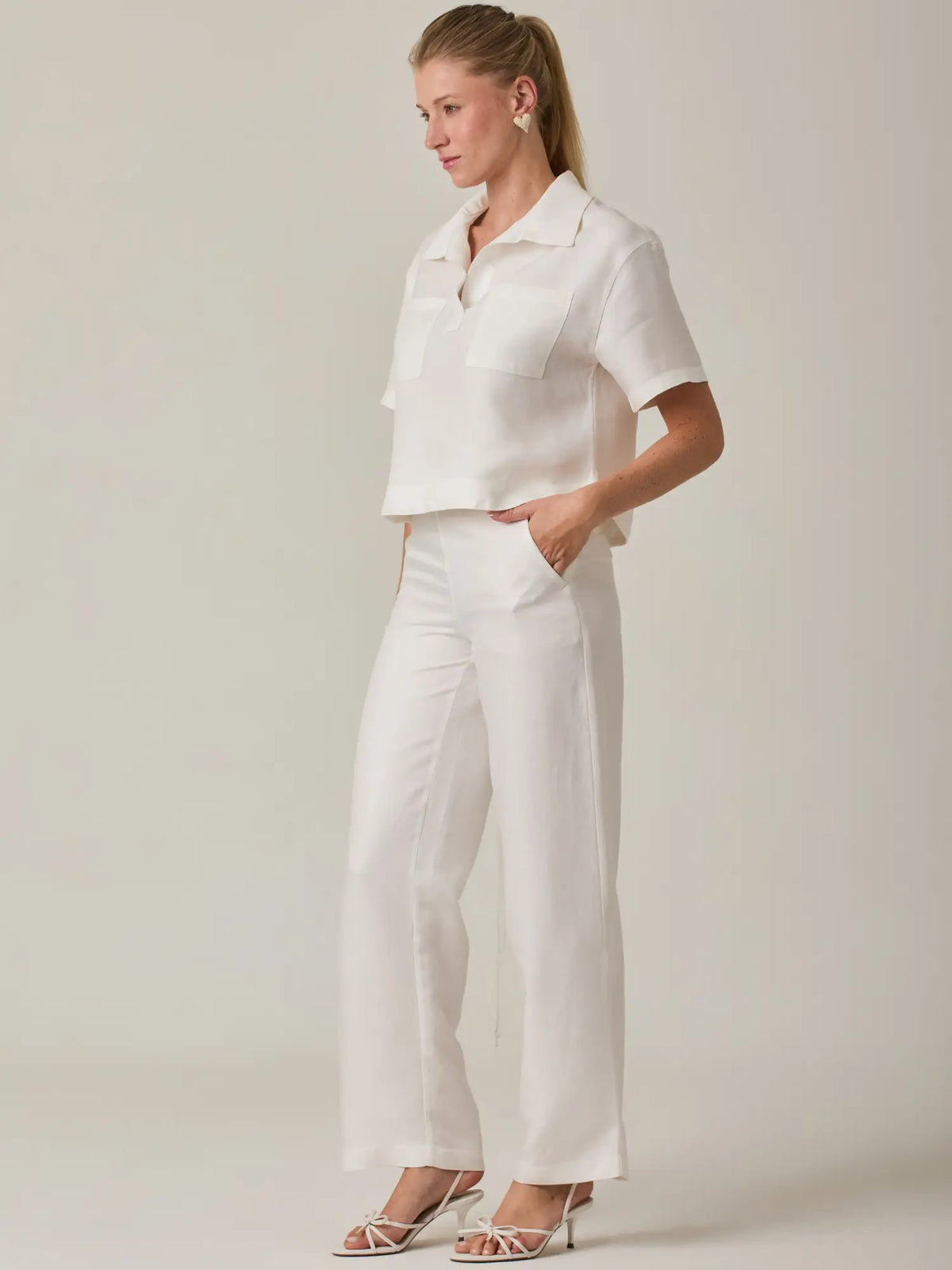 Pantalón largo en tono blanco con diseño clásico y líneas limpias que aportan elegancia natural. Su confección permite un ajuste favorecedor, convirtiéndolo en una prenda esencial para un armario moderno y versátil.