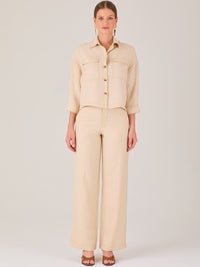 Este pantalón tiene un diseño sofisticado y moderno, confeccionado en un tono beige claro muy versátil. Presenta una silueta de pierna recta y ligeramente amplia, lo que aporta una caída elegante y cómoda. La cintura es de talle medio-alto, con cierre delantero oculto y detalles de pinzas que estilizan la figura. Incluye trabillas para cinturón y bolsillos laterales funcionales, además de costuras marcadas al frente que aportan estructura. Es una prenda ideal para looks de oficina, conjuntos monocromáticos 