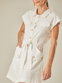 Vestido corto mangas corta tipo chaleco, con botones delanteros, cinturón a tono y escote pico. 

Color: Blanco.

Composición: 85% Rayón 5% poliéster 10% Algodón. 
 corto, de bolsillos laterales. 
