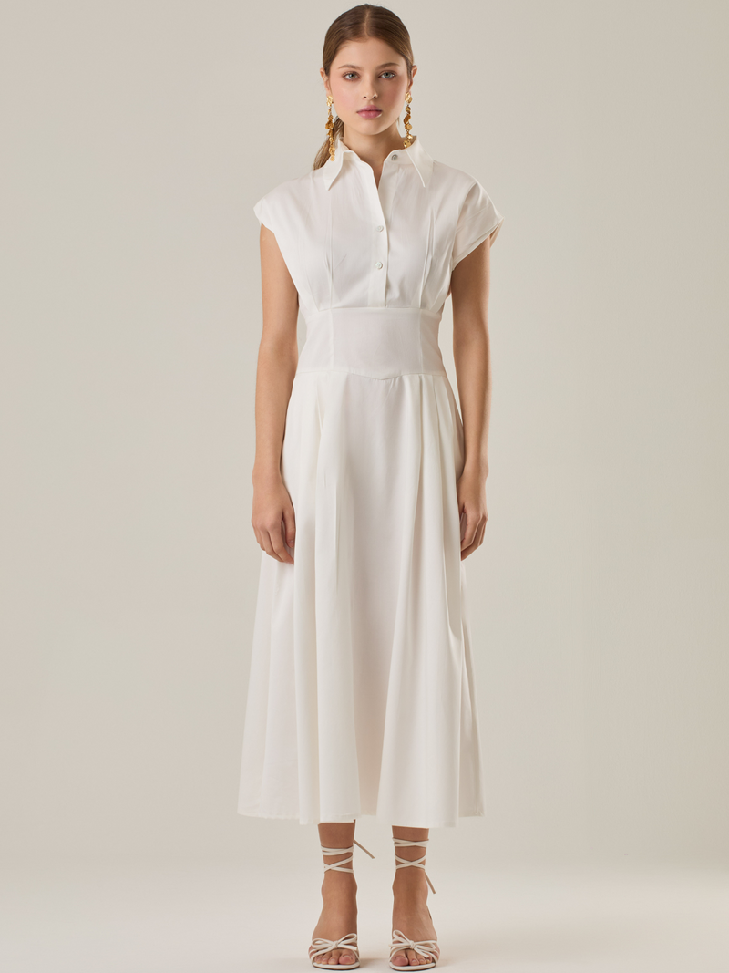 Vestido midi con inspiración safari, ideal para un look sofisticado y versátil. Su diseño con cuello camisero y botones aporta un aire elegante, mientras que los pliegues en la cintura estilizan la silueta. Perfecto para combinar con sandalias o tacones y lograr un outfit atemporal.