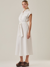 Vestido con mangas con botonadura frontal y cinturón a tono. Tiene bolsillos tipo parche en el pecho que acentúan su aire utilitario, mientras que el largo  y los botones metálicos le dan un acabado elegante y atemporal. Perfecto para un look sofisticado de día.