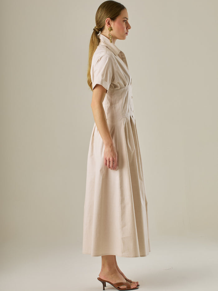Vestido camisero midi con mangas cortas y falda amplia, ideal para un look elegante y relajado. Su diseño con pinzas en el busto realza la figura con sutileza, mientras que los botones al frente aportan un toque clásico y versátil.

Detalles:

Color: Sand

Material: 97% Algodón 3% Spandex