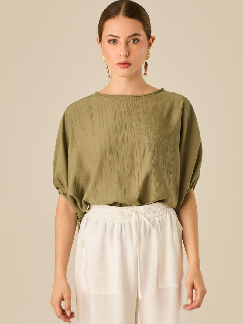 Blusa de caída ligera con detalle acanalado y mangas abullonadas ajustables. Su estilo relajado y delicado la convierte en una prenda versátil y sofisticada, perfecta para elevar looks cotidianos con elegancia sutil.

Detalles:

Color: Olivo