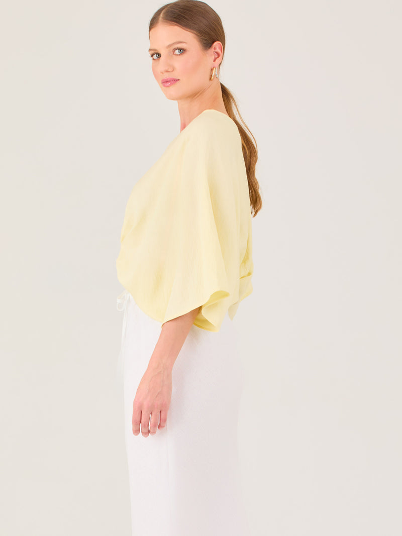 De tela ligera, escote en V y diseño suelto, es ideal para looks frescos y veraniegos. El nudo central le da un toque moderno y femenino.