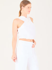 Blusa corta  con diseño cruzado en el escote que forma un tirante ancho asimétrico. Presenta un detalle drapeado sutil en el pecho y elástico en la parte inferior que ajusta a la cintura. Moderna y elegante, ideal para looks frescos y sofisticados

Detalles:

Color: Blanco

Material: 52% Lino 48% Rayon