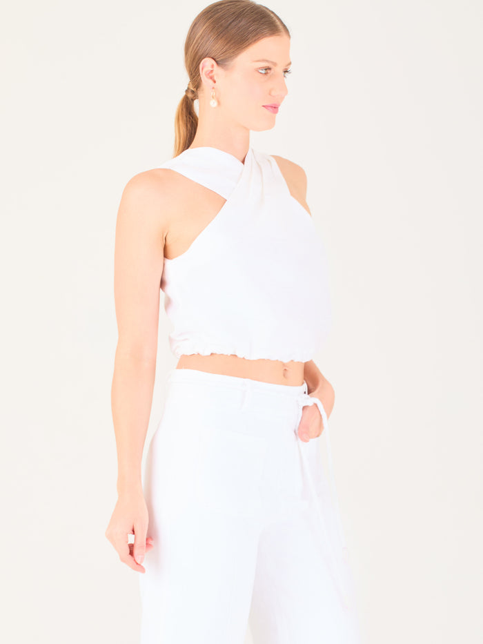 Blusa corta  con diseño cruzado en el escote que forma un tirante ancho asimétrico. Presenta un detalle drapeado sutil en el pecho y elástico en la parte inferior que ajusta a la cintura. Moderna y elegante, ideal para looks frescos y sofisticados

Detalles:

Color: Blanco

Material: 52% Lino 48% Rayon