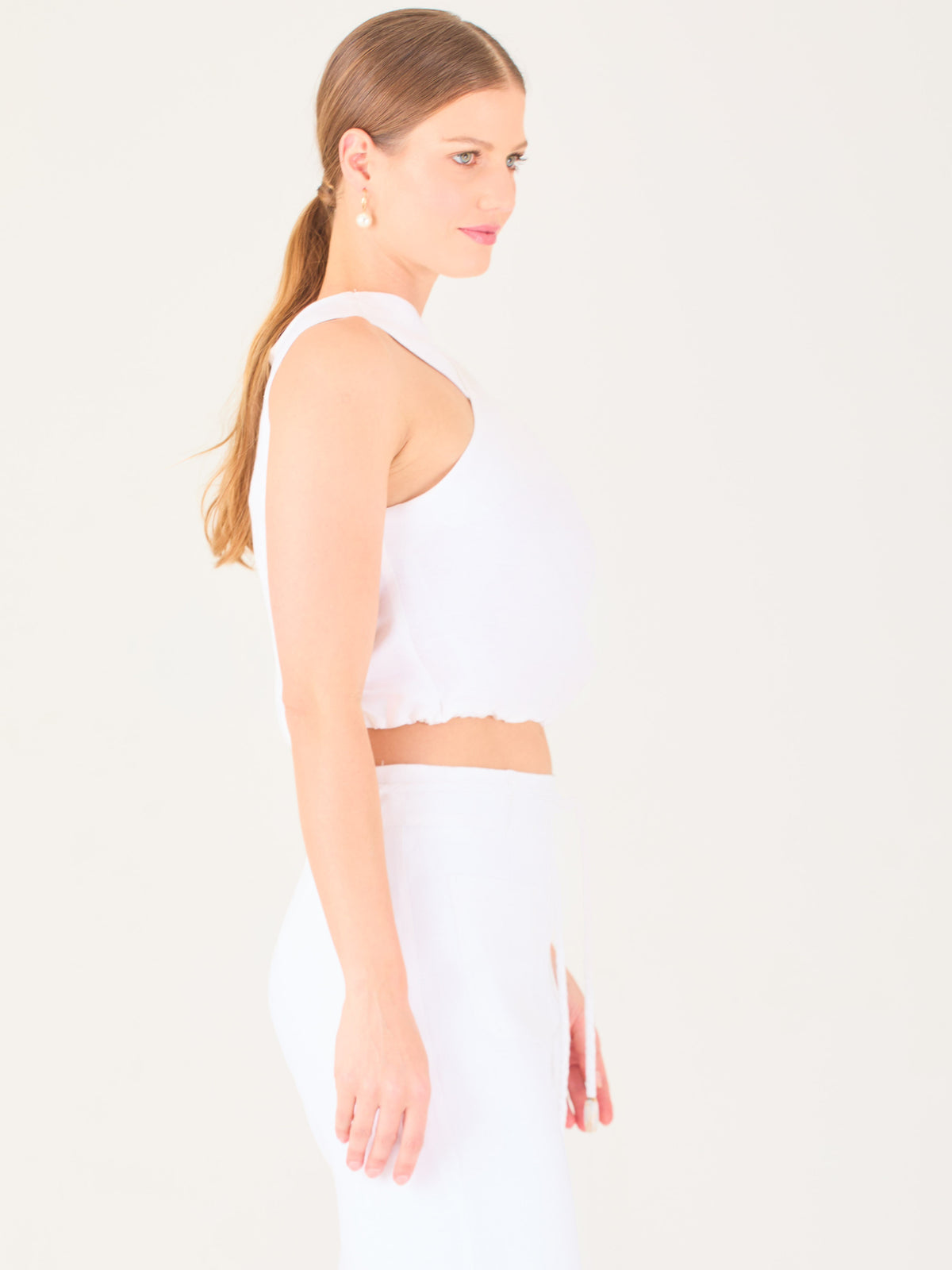 Blusa corta  con diseño cruzado en el escote que forma un tirante ancho asimétrico. Presenta un detalle drapeado sutil en el pecho y elástico en la parte inferior que ajusta a la cintura. Moderna y elegante, ideal para looks frescos y sofisticados

Detalles:

Color: Blanco

Material: 52% Lino 48% Rayon