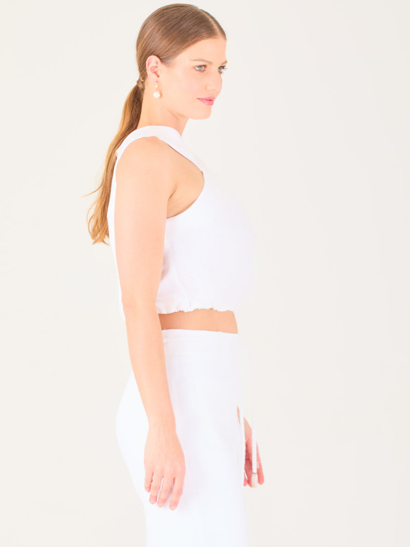 Blusa corta  con diseño cruzado en el escote que forma un tirante ancho asimétrico. Presenta un detalle drapeado sutil en el pecho y elástico en la parte inferior que ajusta a la cintura. Moderna y elegante, ideal para looks frescos y sofisticados

Detalles:

Color: Blanco

Material: 52% Lino 48% Rayon