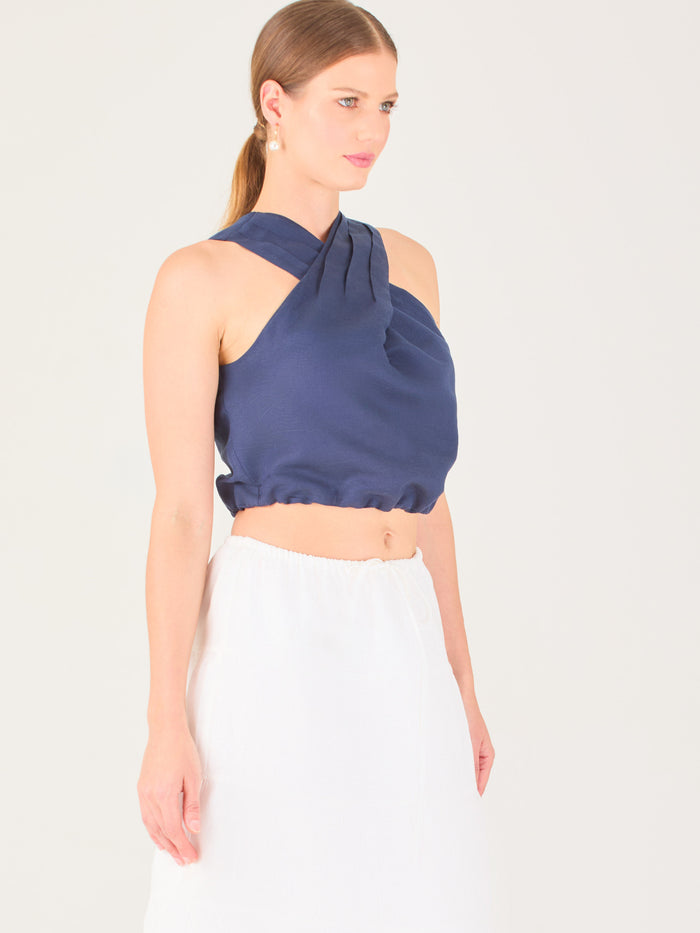 Blusa corta  con diseño cruzado en el escote que forma un tirante ancho asimétrico. Presenta un detalle drapeado sutil en el pecho y elástico en la parte inferior que ajusta a la cintura. Moderna y elegante, ideal para looks frescos y sofisticados

Detalles:

Color: navy

Material: 52% Lino 48% Rayon