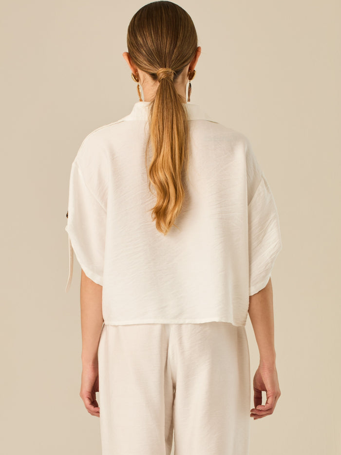 Blusa de silueta relajada con botones al frente, bolsillos tipo parche y mangas con detalle de amarre que aporta un aire desenfadado y chic. Su estilo versátil la convierte en una opción perfecta para looks casuales con un toque sofisticado.

Detalles:

Color: Blanco