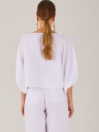 Sofisticada y atemporal, esta blusa de silueta recta se caracteriza por su escote cerrado, líneas limpias y mangas tres cuartos con efecto globo. El diseño pulido la convierte en una prenda versátil para combinar con prendas sastre o looks relajados, ideal para ambientes laborales o estilismos casuales con elegancia natural.
