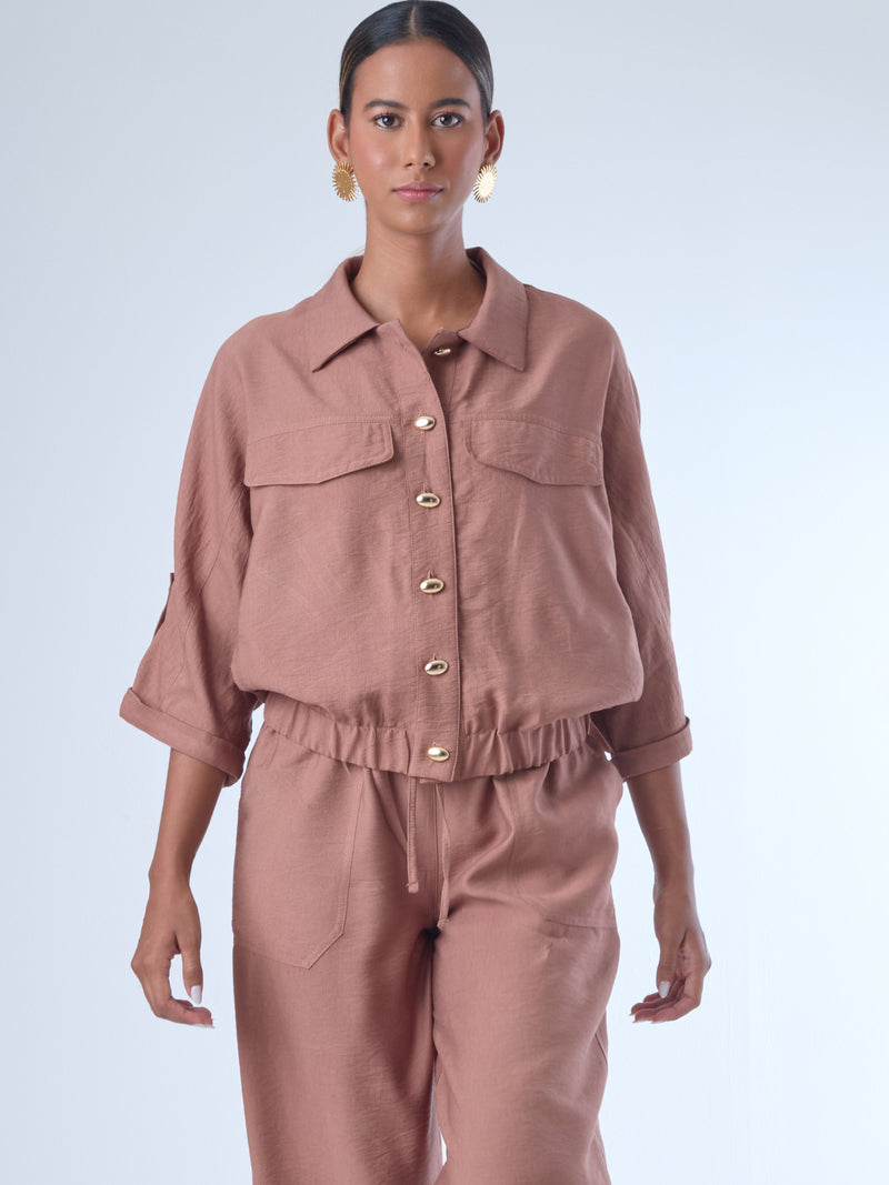 Relajada pero estructurada, esta blusa de silueta amplia combina un diseño utilitario con detalles refinados. Presenta bolsillos de solapa en el pecho, mangas con opción de ajuste y una botonadura dorada que aporta un toque de brillo sutil. Ideal para estilismos casuales con elegancia natural, o para elevar conjuntos relajados con una prenda clave y atemporal.