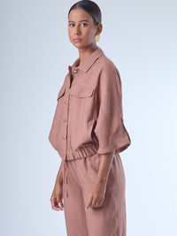 Relajada pero estructurada, esta blusa de silueta amplia combina un diseño utilitario con detalles refinados. Presenta bolsillos de solapa en el pecho, mangas con opción de ajuste y una botonadura dorada que aporta un toque de brillo sutil. Ideal para estilismos casuales con elegancia natural, o para elevar conjuntos relajados con una prenda clave y atemporal.
