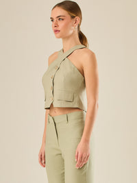 Chaleco corto con escote halter cruzado y cierre frontal con botones, ideal para un look moderno y sofisticado. Su diseño estructurado realza la figura con elegancia, perfecto para combinar con prendas de tiro alto y crear conjuntos contemporáneos con personalidad.

Detalles:

Color: Verde
