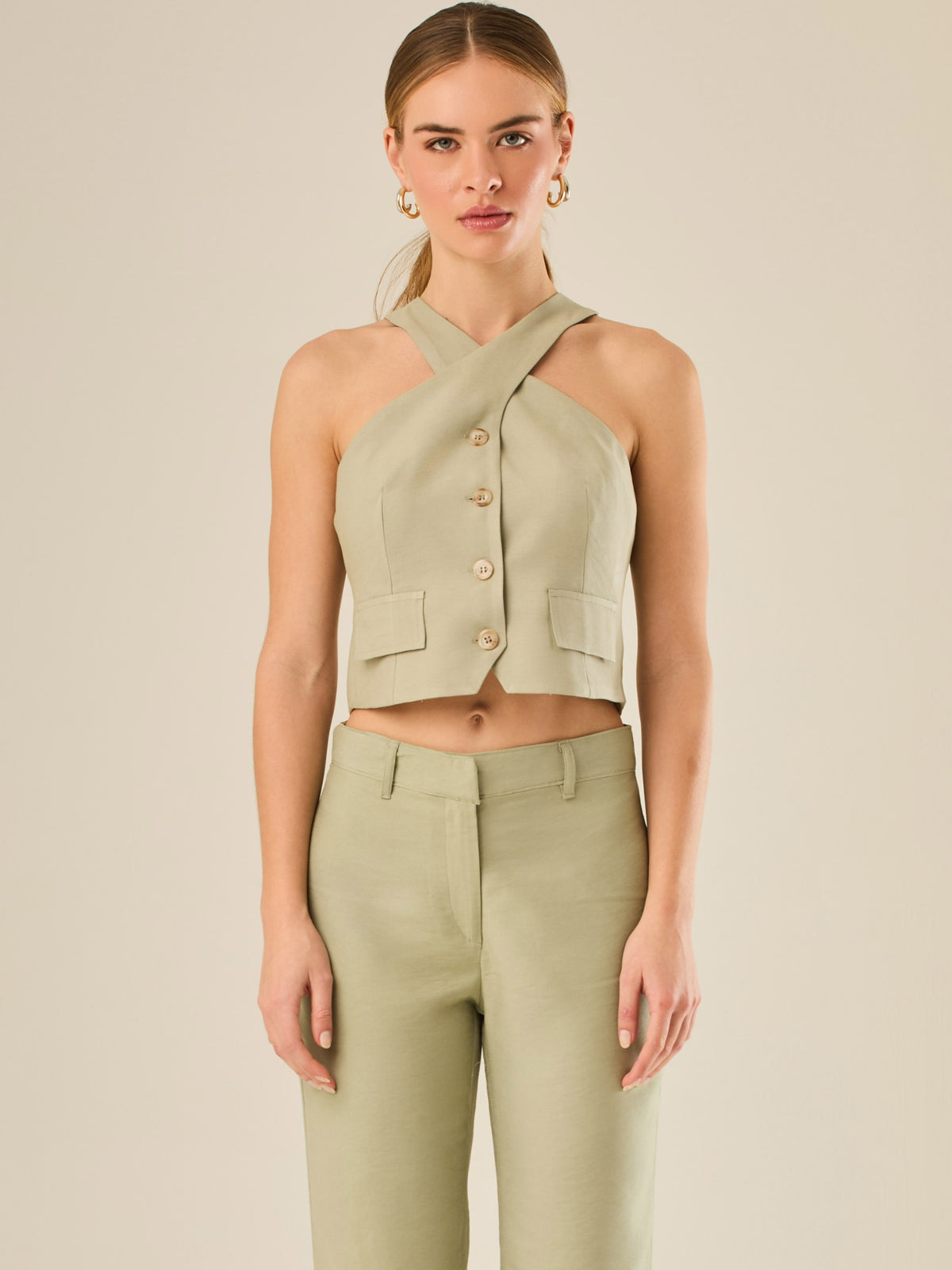 Chaleco corto con escote halter cruzado y cierre frontal con botones, ideal para un look moderno y sofisticado. Su diseño estructurado realza la figura con elegancia, perfecto para combinar con prendas de tiro alto y crear conjuntos contemporáneos con personalidad.

Detalles:

Color: Verde