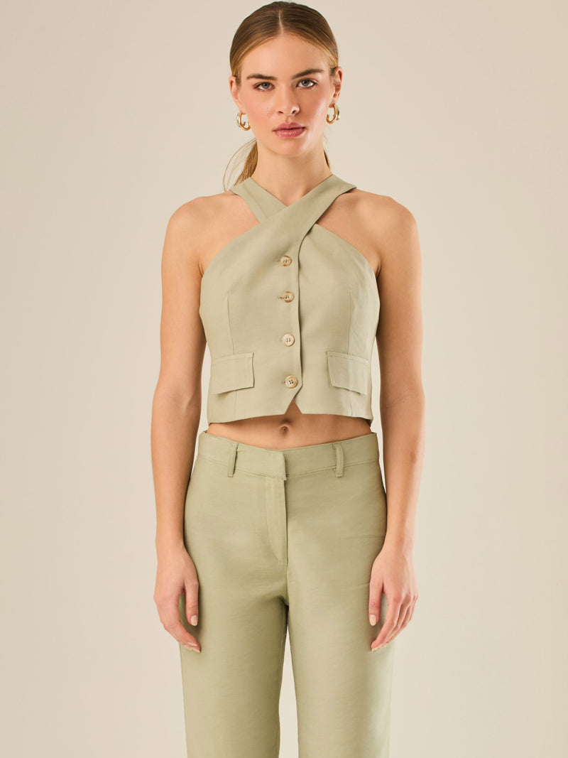 Chaleco corto con escote halter cruzado y cierre frontal con botones, ideal para un look moderno y sofisticado. Su diseño estructurado realza la figura con elegancia, perfecto para combinar con prendas de tiro alto y crear conjuntos contemporáneos con personalidad.

Detalles:

Color: Verde