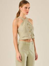 Chaleco corto con escote halter cruzado y cierre frontal con botones, ideal para un look moderno y sofisticado. Su diseño estructurado realza la figura con elegancia, perfecto para combinar con prendas de tiro alto y crear conjuntos contemporáneos con personalidad.

Detalles:

Color: Verde