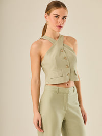 Chaleco corto con escote halter cruzado y cierre frontal con botones, ideal para un look moderno y sofisticado. Su diseño estructurado realza la figura con elegancia, perfecto para combinar con prendas de tiro alto y crear conjuntos contemporáneos con personalidad.

Detalles:

Color: Verde