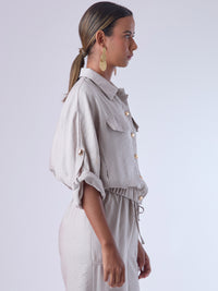Relajada pero estructurada, esta blusa de silueta amplia combina un diseño utilitario con detalles refinados. Presenta bolsillos de solapa en el pecho, mangas con opción de ajuste y una botonadura dorada que aporta un toque de brillo sutil. Ideal para estilismos casuales con elegancia natural, o para elevar conjuntos relajados con una prenda clave y atemporal.