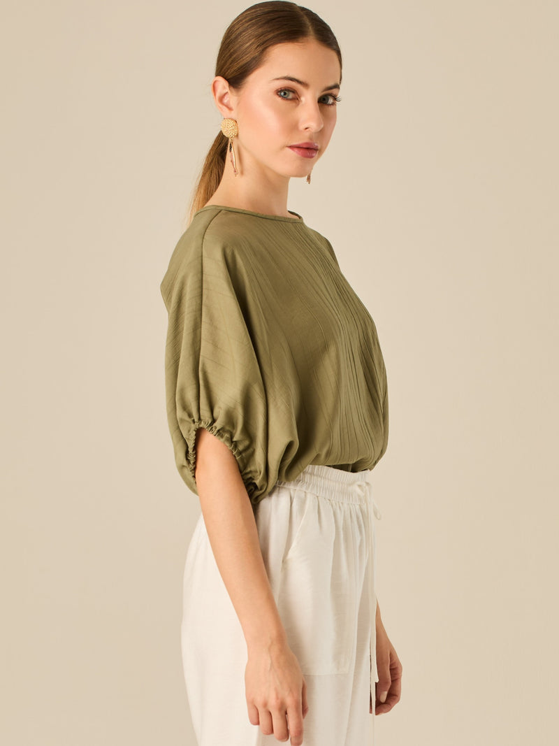Blusa de caída ligera con detalle acanalado y mangas abullonadas ajustables. Su estilo relajado y delicado la convierte en una prenda versátil y sofisticada, perfecta para elevar looks cotidianos con elegancia sutil.

Detalles:

Color: Olivo