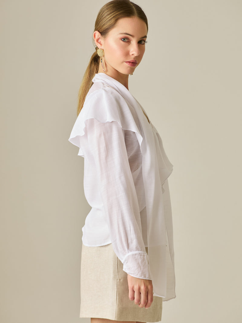 Blusa de manga larga con detalle de volantes en el escote y lazo largo para anudar. Su diseño ligero y delicado aporta movimiento y sofisticación, ideal para un look femenino con un aire romántico y moderno.

Detalles:
